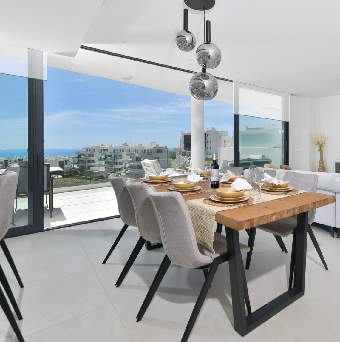 Bright living and dining room with sea views in a rental home managed by Solkysten